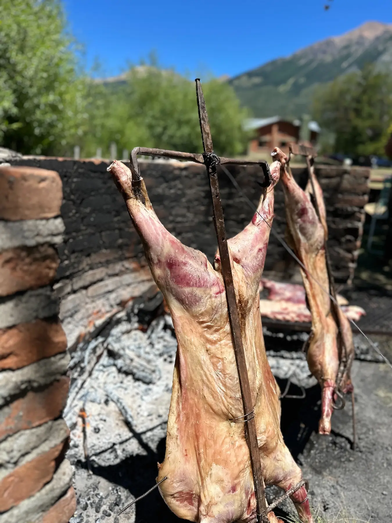 Cordero cocinándose al fuego en el fogón exterior
