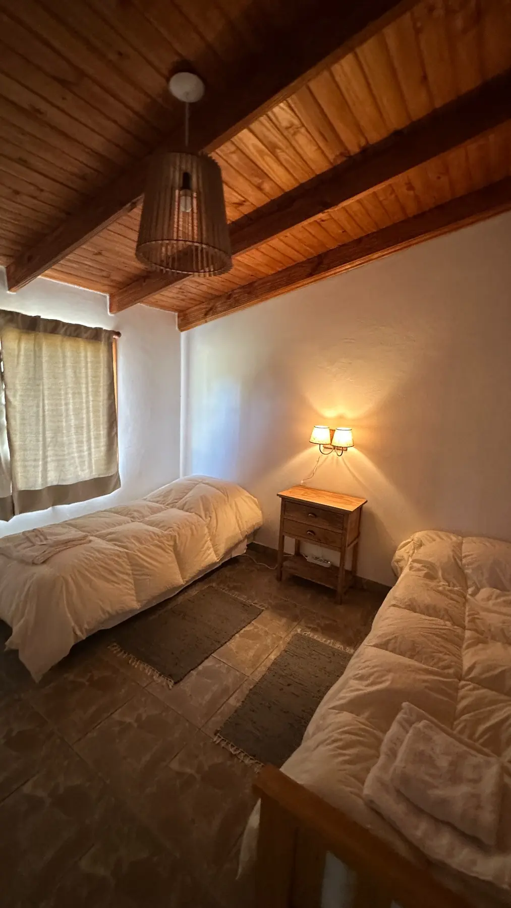 Dormitorio con dos camas individuales y techo de madera