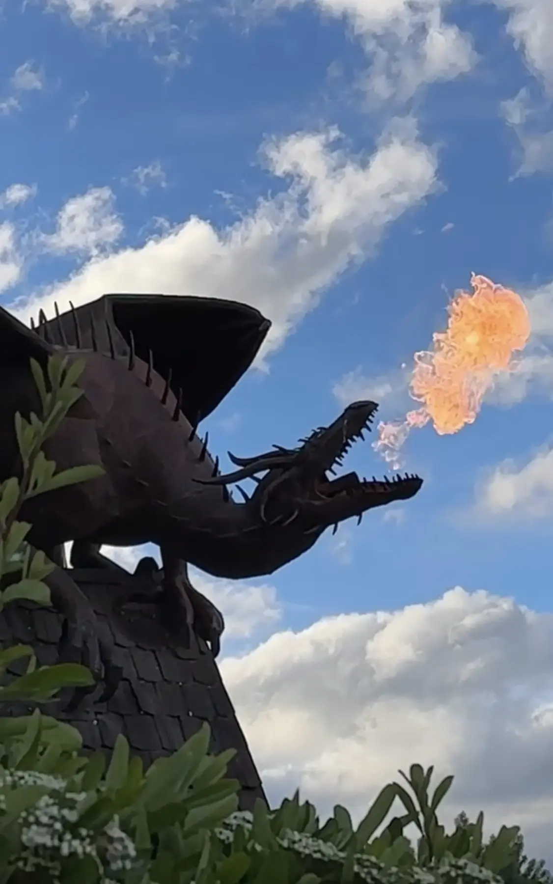 Escultura de dragón lanzando fuego bajo el cielo patagónico