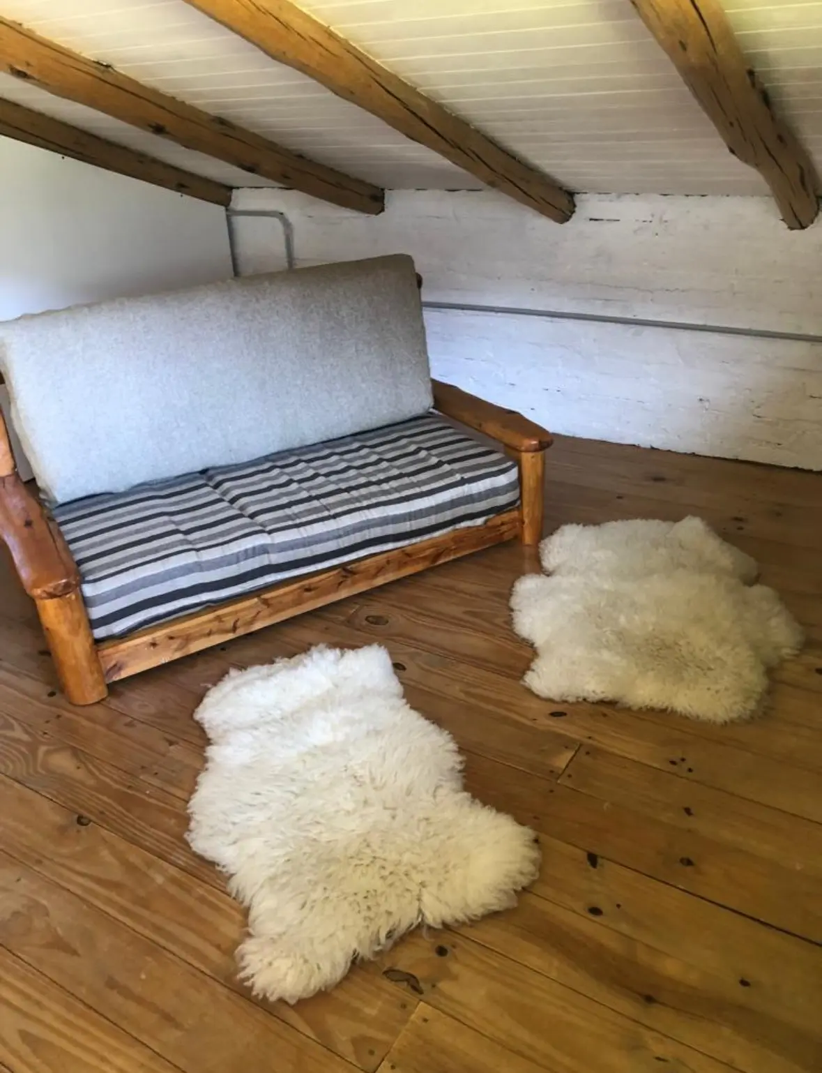 Rincón de descanso en el altillo con madera y pieles