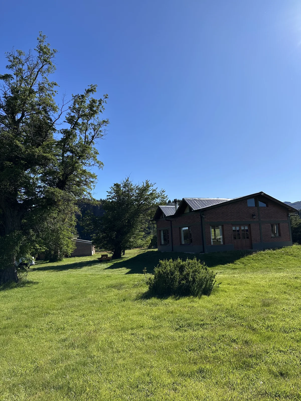 Fachada de Refugio Cordillerano rodeada de árboles